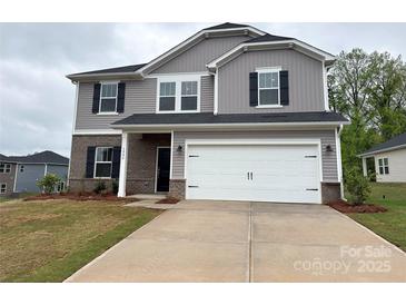 Charming two-story home with gray siding, brick accents, and a spacious two-car garage at 1986 Paddlewheel Dr, Stanley, NC 28164