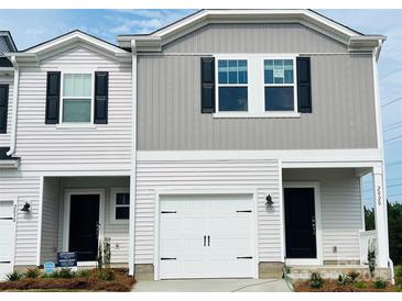 Charming townhome featuring neutral siding, a one-car garage, and a welcoming front entrance at 2020 Old Rivers Rd, Concord, NC 28027