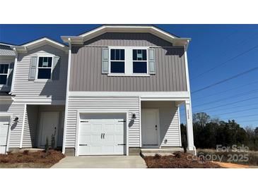 Charming two-story townhome features a one-car garage and welcoming front entrance at 2020 Old Rivers Rd, Concord, NC 28027