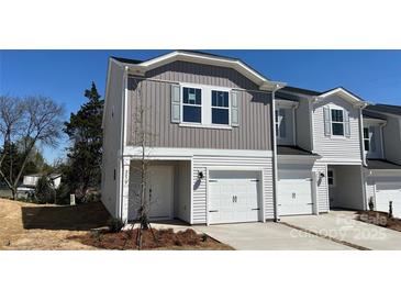 Charming two-story townhome with white siding, gray accents, and an attached single-car garage at 2070 Old Rivers Rd, Concord, NC 28027