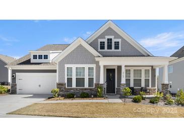 Charming two-story home featuring stone accents, a covered porch, and a well-manicured lawn at 2768 Suffolk Pl, Fort Mill, SC 29715