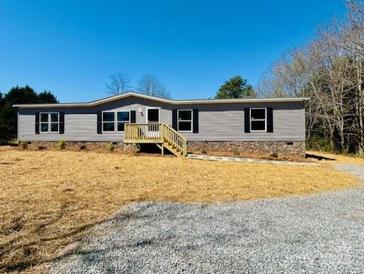 Charming single-story home with gray siding, stone accents, and a well-maintained front yard at 3144 Rickwood Dr, Newton, NC 28658