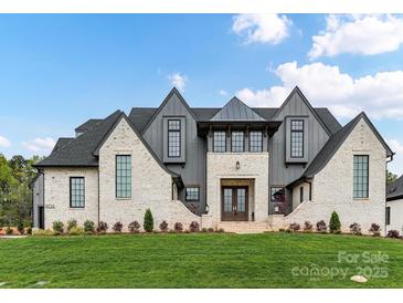 Stunning two-story home featuring a light-colored brick facade, gabled roof, and expansive front lawn at 406 Sugar Maple Ln, Weddington, NC 28104
