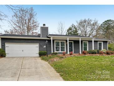 Charming single-story home featuring a well-manicured front yard and attached garage at 6501 Thamesmead Ln, Mint Hill, NC 28227