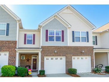 Charming two-story townhouse featuring brick accents, a one-car garage, and a welcoming front porch at 7426 Calhoun Falls Dr, Rock Hill, SC 29732