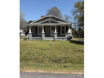 Charming single-story home with a covered front porch and well-maintained lawn at 1011 Buick Ave, Kannapolis, NC 28083