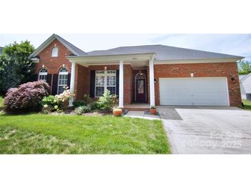 Charming brick home boasts a lush front yard, well-maintained landscaping, and inviting curb appeal at 1021 Glen Laurel Dr, Fort Mill, SC 29707