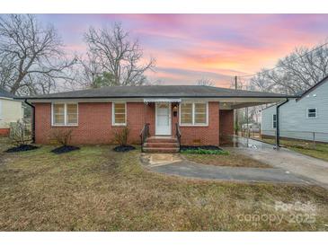 Charming brick home featuring a covered parking area, landscaped front yard, and inviting front porch with sunrise background at 108 White Oak St, Chester, SC 29706