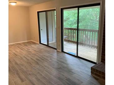 Bright living room with sliding glass doors leading to a deck, and brick fireplace at 11022 Harrowfield Rd, Charlotte, NC 28226