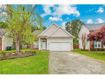 Charming home featuring neutral siding, a two-car garage, and a well-manicured front lawn at 13521 Michael Lynn Rd, Charlotte, NC 28278