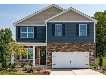 Charming two-story home featuring a stone-accented facade, an attached two-car garage, and beautifully manicured landscaping at 140 Falling Up Ln, Salisbury, NC 28147