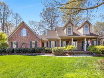 Charming brick home featuring a well-manicured lawn, covered porch and mature landscaping at 153 Stafford Estates Dr, Salisbury, NC 28146