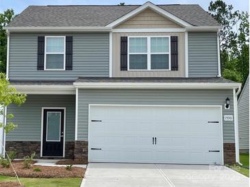 Two-story home with gray siding, stone accents, a two-car garage, and a well-maintained lawn at 1530 Doran Ter, Richburg, SC 29729