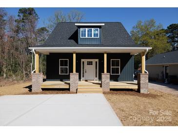 Charming home features a welcoming front porch with brick pillars and a well-manicured lawn at 202 Westerwood Dr, Rock Hill, SC 29732