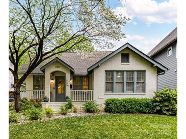 Charming cottage-style home with a well-maintained lawn and inviting front porch with beautiful flowers at 925 E 35Th St, Charlotte, NC 28205