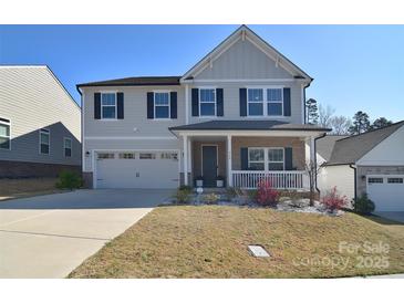 Charming two-story home with a well-manicured lawn, attached garage and inviting front porch at 966 Scotch Meadows Loop, Monroe, NC 28110
