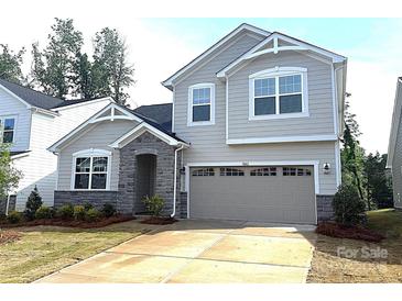 Charming two-story home featuring stone accents, a two-car garage, and a well-manicured lawn at 9842 Quercus Ln, Huntersville, NC 28078