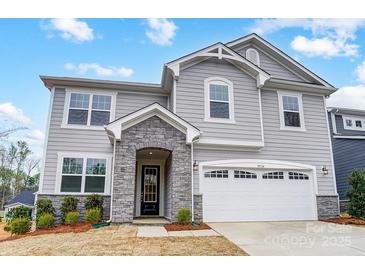 Charming two-story home with gray siding, stone accents, a two-car garage, and a well-maintained front yard at 9934 Cask Way, Huntersville, NC 28078
