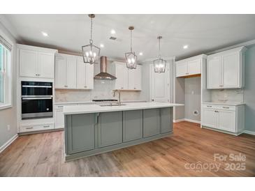 Bright kitchen features a gray island, stainless appliances, pendant lighting, and white cabinetry at 9957 Cask Way, Huntersville, NC 28078