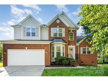 Charming two-story brick home featuring a two-car garage and well-manicured front lawn at 2514 Waters Vista Cir, Charlotte, NC 28213