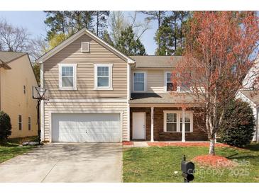 Charming two-story home featuring stone accents, tan siding and an attached two-car garage in a well-manicured yard at 3308 Lemongrass Ln, Charlotte, NC 28214