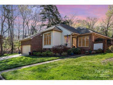 Charming brick home featuring a manicured lawn and an attached two-car garage at 5125 Waxwind Ln, Charlotte, NC 28226