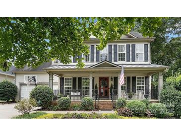 Charming home featuring a lovely front porch, manicured landscaping, and classic black shutters at 7215 Meyer Rd, Fort Mill, SC 29715