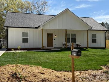 Charming home with a well-manicured lawn and inviting front porch with rocking chairs at 1022 Johnna Ln, Indian Land, SC 29707