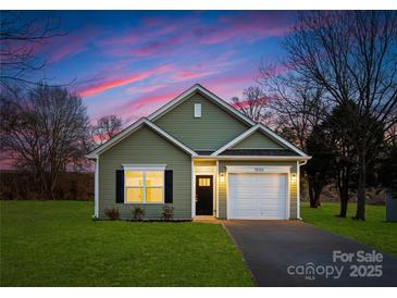 Charming single-story home with a well-maintained lawn, garage, and inviting facade set against a colorful sky at 1026 Dooley Dr, Charlotte, NC 28227