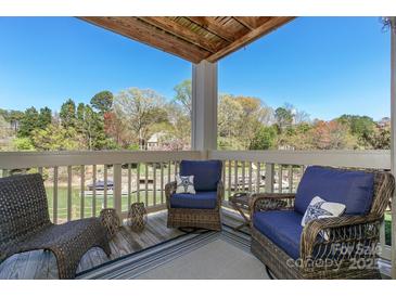 Inviting balcony with comfortable seating and a beautiful view of the lake and surrounding trees at 104 Pier 33 Dr # 308, Mooresville, NC 28117