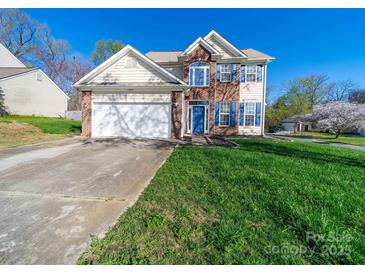 Two-story home with brick details, blue shutters, attached garage, and a well-maintained front yard at 14802 Rolling Sky Dr, Charlotte, NC 28273