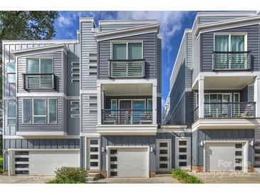 Modern townhome exterior featuring balconies, gray siding, and attached garages for convenient parking at 1651 Duckworth Ave, Charlotte, NC 28208