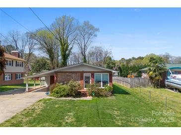 Charming brick home with well-maintained lawn, mature trees, and covered parking at 207 N Sims St, Kings Mountain, NC 28086