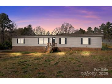 Charming single-story home with brick foundation, wood siding, and a lush, landscaped yard at 2154 Withers Dr, Maiden, NC 28650
