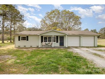 Charming single-story home with a two-car garage and a cozy front porch sitting area at 217 Cedarhurst Ln, Clover, SC 29710