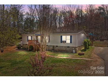 Charming single-story home with a wooden porch, stone foundation and mature trees in a wooded setting at 4793 Appaloosa Ln, Maiden, NC 28650
