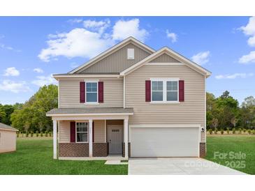 Charming two-story home featuring red window shutters, a front porch, and an attached two-car garage at 711 Olde England Dr, Lincolnton, NC 28092