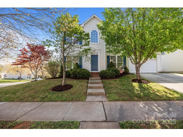 Charming two-story home with a well-manicured lawn, inviting walkway, and vibrant landscaping at 7262 April Mist Trl, Huntersville, NC 28078