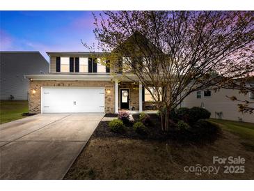 Charming two-story brick home with a well-manicured lawn and attached two-car garage at 10773 Sapphire Trl, Davidson, NC 28036