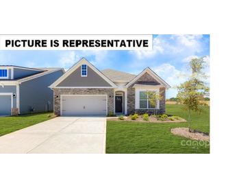 Charming single-story home boasts a stone facade, well-manicured lawn, and attached two-car garage at 124 N Shayna Rd, Troutman, NC 28166