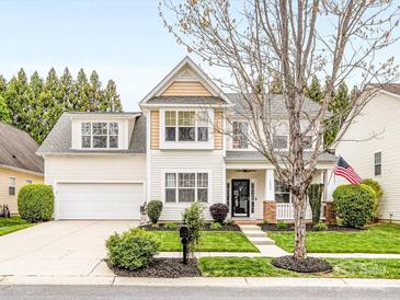 Charming two-story home featuring a well-manicured lawn, attached garage, and welcoming front porch at 14923 Colonial Park Dr, Huntersville, NC 28078