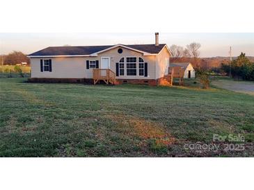 Charming single-story home with a well-maintained lawn, wooden porch, and classic black shutters at 1524 J Rhyne Reep Rd, Vale, NC 28168