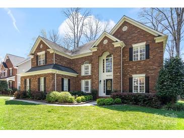 Charming brick two-story home with manicured lawn and beautiful landscaping at 16123 Chiltern Ln, Huntersville, NC 28078
