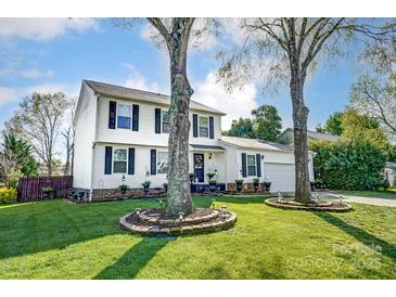 Charming two-story home with classic white siding, black shutters, and well-manicured lawn with mature trees at 2243 Flint Glenn Ln, Charlotte, NC 28262