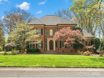 Beautiful two-story brick home with manicured lawn and mature trees at 3600 Castellaine Dr, Charlotte, NC 28226