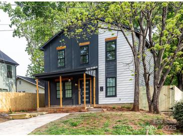 Charming two-story home with a modern exterior and inviting front porch perfect for relaxing and enjoying the neighborhood at 411 Cemetery St, Charlotte, NC 28216