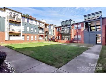 Exterior of a brick building with a view of the grassy courtyard at 474 New Bern Station Ct, Charlotte, NC 28209