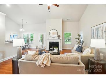 Bright living room with hardwood floors, a fireplace, and neutral decor for a relaxing atmosphere at 5032 Eagles Crest Ln, Gastonia, NC 28056