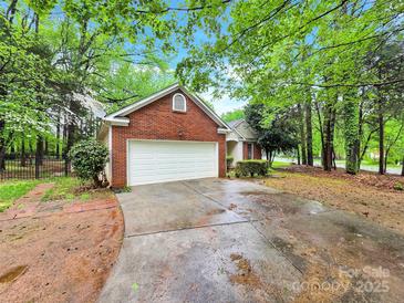 Traditional brick and vinyl home with a two-car garage and mature trees at 6520 White Pine Ln, Charlotte, NC 28262