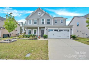 Charming two-story home featuring a well-manicured lawn, flower beds, and an attached two-car garage at 7278 Waterwheel St, Concord, NC 28025